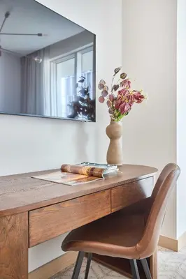 a table with a vase of flowers and a mirror at Frank Porter - Vida Dubai Mall Tower 2 in Dubai