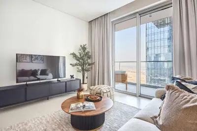 a living room with a table and a large window at Frank Porter - Vida Dubai Mall Tower 2 in Dubai
