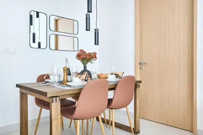 a dining room with a wooden table and chairs at Frank Porter - Vida Dubai Mall Tower 2 in Dubai