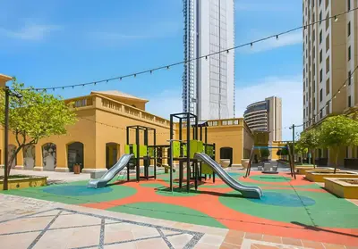 an empty playground in a city with buildings at Rimal 5, JBR - 3 Bedroom with Maid's Room Apartment - Allsopp & Allsopp in Dubai