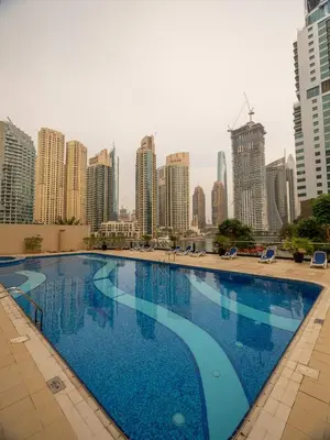 a large swimming pool with a city skyline in the background at Stunning 2bd marina views prime location high floor in Dubai