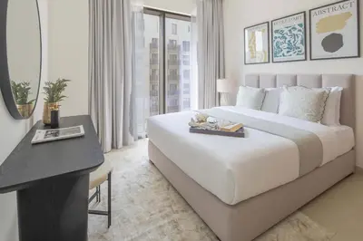 a bedroom with a large white bed and a desk at Frank Porter - Rosewater at Creek Beach 3 in Dubai