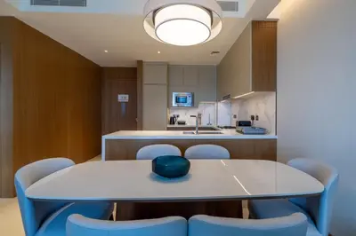 a dining room with a table and chairs and a kitchen at Luxury 2BR at Address Opera with Burj Khalifa view in Dubai