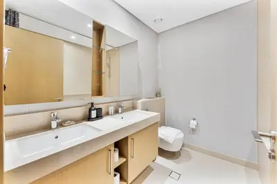 a bathroom with a sink and a mirror and a toilet at Beachfront Vibe 2BR APT - Walk to JBR & Bluewaters in Dubai