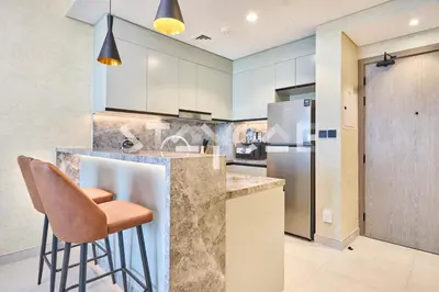 a kitchen with a counter and a bar with stools at Staycae Holiday Homes Golf Gate - Damac Hills in Dubai