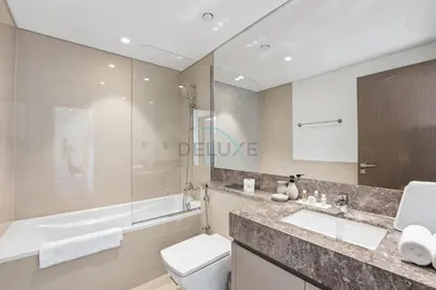 a bathroom with a toilet and a sink and a tub at Steps from Dubai Mall and Burj Khalifa, with Seamless Metro Access to Dubai Marina and Palm Jumeirah - Act One Act Two Tower 1, Downtown Dubai by Deluxe Holiday Homes in Dubai