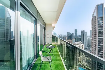 a balcony with a table and chairs on top of a building at Steps from Dubai Mall and Burj Khalifa, with Seamless Metro Access to Dubai Marina and Palm Jumeirah - Act One Act Two Tower 1, Downtown Dubai by Deluxe Holiday Homes in Dubai