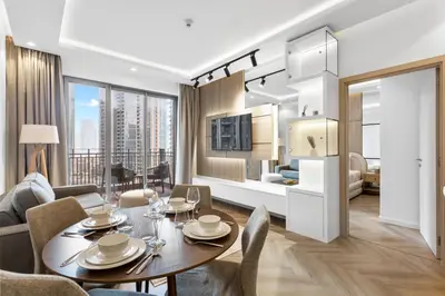a dining room with a table and chairs and a living room at Stylish Stay 2 Bedroom Minutes from Burj Khalifa in Dubai