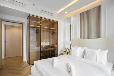 a white bedroom with a large white bed and a room at Stylish Stay 2 Bedroom Minutes from Burj Khalifa in Dubai