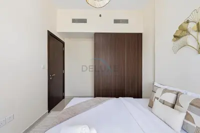a bedroom with a white bed and a wooden door at Located Near Dubai Mall, Burj Khalifa and Dubai Canal, with Easy Access to Dubai Metro - Vera Tower, Business Bay by Deluxe Holiday Homes in Dubai