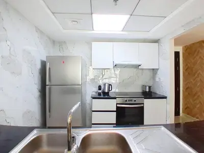 a kitchen with a sink and a refrigerator at Vacationer l 1 Bedroom Stunning Marina Skyline l Free Pool, Gym Access in Dubai