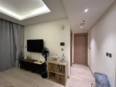 a living room with a flat screen tv and a desk at Stunning 1 Bed in Meydan in Dubai