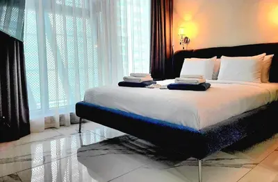 a bedroom with a large bed with white sheets and pillows at Stylish Studio in J One, near Burj Khalifa, Mall in Dubai