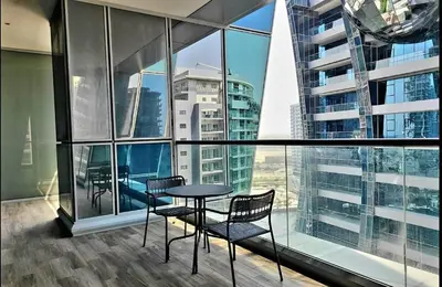 a table and chairs in a room with large windows at Stylish Studio in J One, near Burj Khalifa, Mall in Dubai
