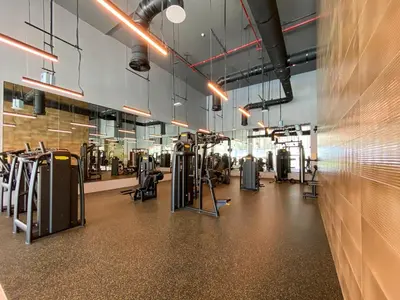 a gym with rows of exercise equipment and a wall at Forte Tower 2 - 3 Bedroom with Maid's Room Apartment - Allsopp & Allsopp in Dubai