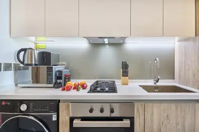 a kitchen with a sink and a stove top oven at Modern Studio in Business Bay with Pool, Gym & Canal View in Dubai
