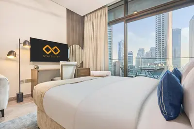 a hotel room with a bed and a large window at Modern Studio in Business Bay with Pool, Gym & Canal View in Dubai