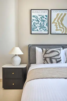 a bedroom with a bed and a table with a lamp at Frank Porter - Azizi Park Avenue in Dubai