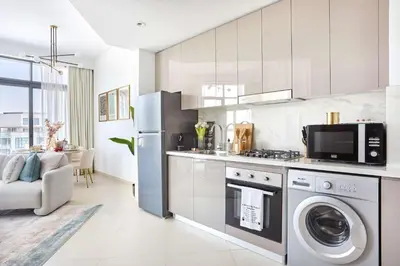 a kitchen with a refrigerator and a stove top oven at Frank Porter - Azizi Park Avenue in Dubai