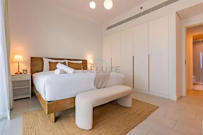 a white bedroom with a bed and a bench at Beachfront Stay with Full Sea Views, Walking Distance to The Walk, JBR Beach, and Dubai Marina - La Vie, Jumeirah Beach Residence by Deluxe Holiday Homes in Dubai