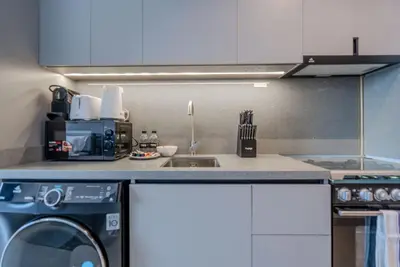 a kitchen with a sink and a washing machine at TRPS - MAG EYE 970, MBR - Modern and Cozy Studio, Furnished, MBR Living in Dubai