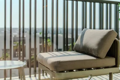 a chair with a pillow sitting on a balcony at TRPS - MAG EYE 970, MBR - Modern and Cozy Studio, Furnished, MBR Living in Dubai