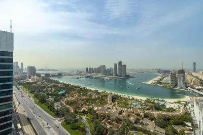 a view of a city with a river and buildings at Maison Privee - High-Floor Haven with Open Sea Views on Palm Entry in Dubai