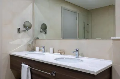 a bathroom with a sink and a mirror at Maison Privee - High-Floor Haven with Open Sea Views on Palm Entry in Dubai