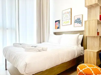 a bedroom with a bed with two towels on it at Elegant Studio in JVC in Dubai