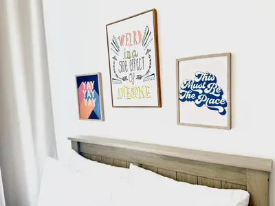 a room with three framed posters on a white wall at Elegant Studio in JVC in Dubai