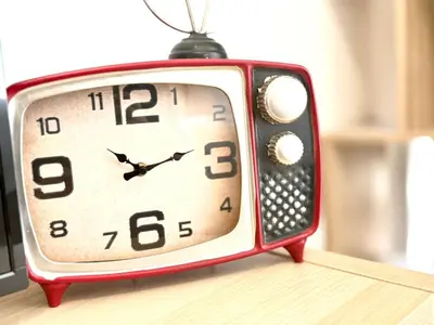 a small red clock sitting on top of a table at Elegant Studio in JVC in Dubai