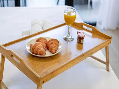 a table with a plate of croissants and a glass of orange juice at Livin' Holidays - Studio - Riviera Elegance in Dubai