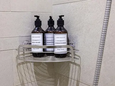 four bottles of wine sitting on a shelf in a bathroom at Livin' Holidays - Studio - Riviera Elegance in Dubai