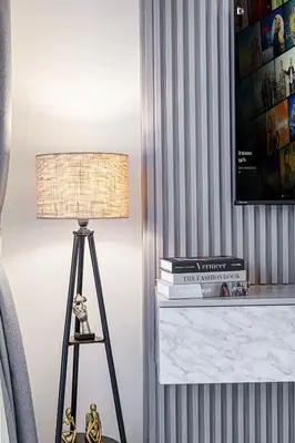 a lamp sitting on a table with a pile of books at Livin' Holidays - Studio - Riviera Elegance in Dubai