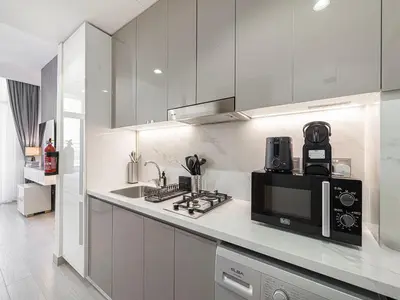 a kitchen with a counter top with a microwave at Livin' Holidays - Studio - Riviera Elegance in Dubai