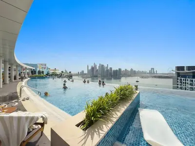 a large swimming pool with people in the water at Stylish Studio with Rooftop Pool on the Palm in Dubai