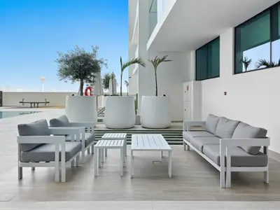 a living room with couches and a coffee table at Chic Studio with Balcony, Gym & Pools in JVC in Dubai