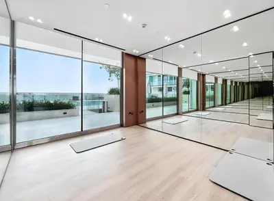 an empty room with windows and yoga mats at Chic Studio with Balcony, Gym & Pools in JVC in Dubai