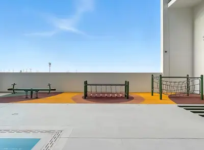 two benches in an empty building with a pool at Chic Studio with Balcony, Gym & Pools in JVC in Dubai