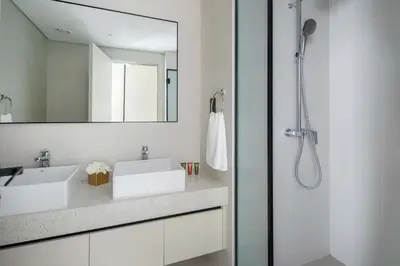a white bathroom with a sink and a mirror at Frank Porter - Marina Vista Tower 1 in Dubai