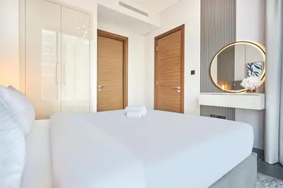 a bedroom with a white bed and a mirror at STAY BY LATINEM Luxury 1BR plus study Holiday Home CC 2408 in Dubai