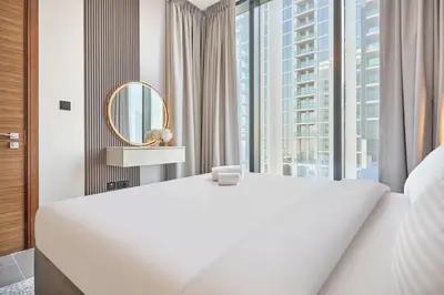 a bedroom with a large white bed and a large window at STAY BY LATINEM Luxury 1BR plus study Holiday Home CC 2408 in Dubai