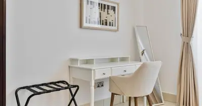 a white desk and a chair in a room at Downtown 2BHK Iconic Burj Khalifa Views in Dubai