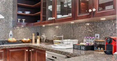 a kitchen with wooden cabinets and a counter top at Downtown 2BHK Iconic Burj Khalifa Views in Dubai