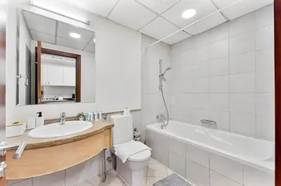 a bathroom with a sink and a toilet and a tub at Splendid Studio near Canal & famous Golf Clubs in Dubai