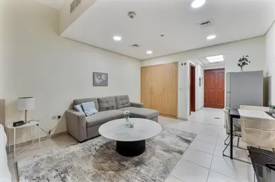 a living room with a couch and a table at Splendid Studio near Canal & famous Golf Clubs in Dubai