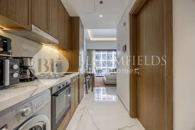a kitchen with a washer and dryer at Bloomfields Lumière Stu Azizi Riviera in Dubai