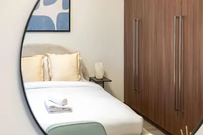 a bedroom with a bed and a wooden cabinet at GuestReady - High-Floor 2BR | City and Canal View in Dubai