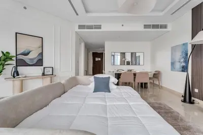 a bedroom with a large bed and a dining room at GuestReady - High-Floor 2BR | City and Canal View in Dubai