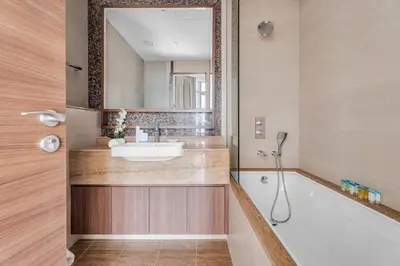 a bathroom with a sink and a tub and a mirror at GuestReady - High-Floor 2BR | Canal and City View in Dubai